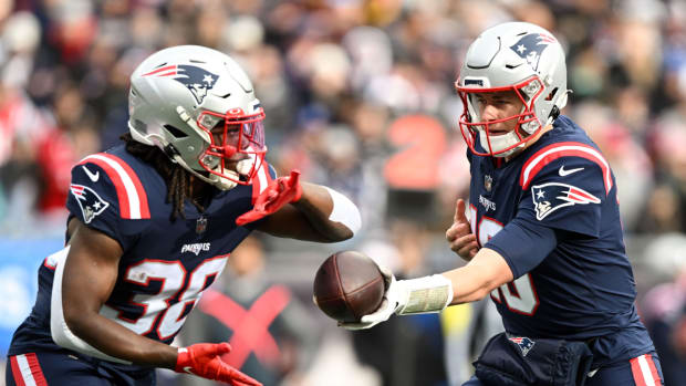 Patriots running back Rhamondre Stevenson is handed the ball from quarterback Mac Jones during a game vs. the Dolphins.